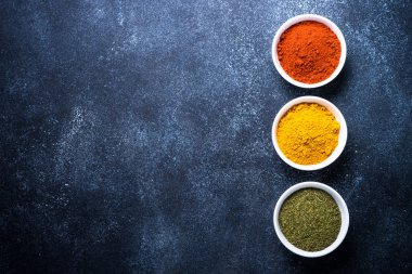 Taş masada bir kase içinde çeşitli baharatlar. 