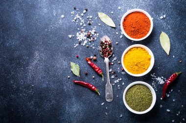 Taş masada bir kase içinde çeşitli baharatlar. 