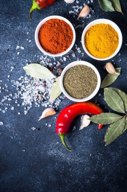 Taş masada bir kase içinde çeşitli baharatlar. 