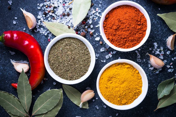 Diverse kruiden in een kommen op stenen tafel. — Stockfoto