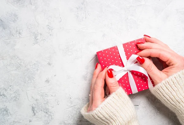 Vrouw verpakking rode kerst presenteren vak. — Stockfoto