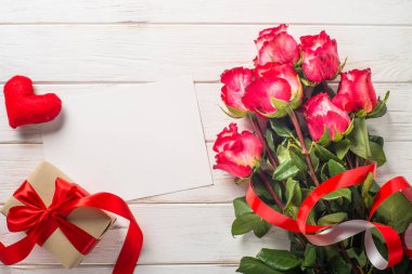 Kırmızı gül çiçek ve ahşap masa üzerinde mevcut kutusu.