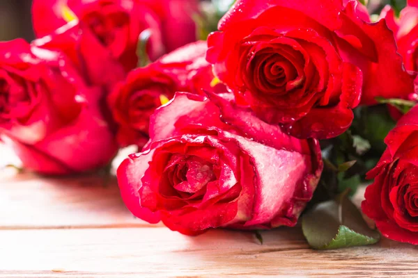 Czerwony kwiat róży na drewnianym stole. — Zdjęcie stockowe