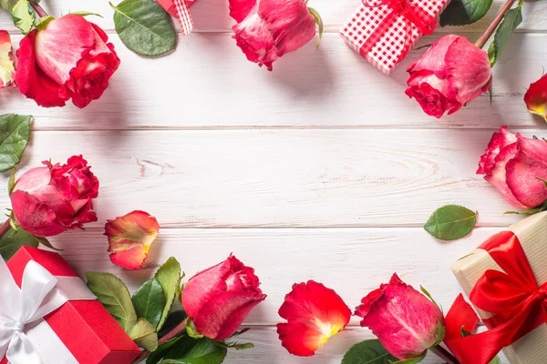 Rood roze bloem en huidige vak op houten tafel. — Stockfoto