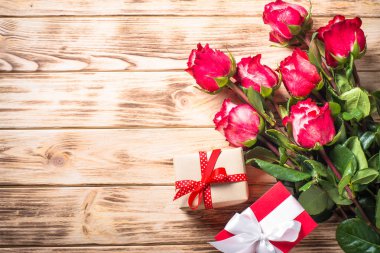 Kırmızı gül çiçek ve ahşap masa üzerinde mevcut kutusu.