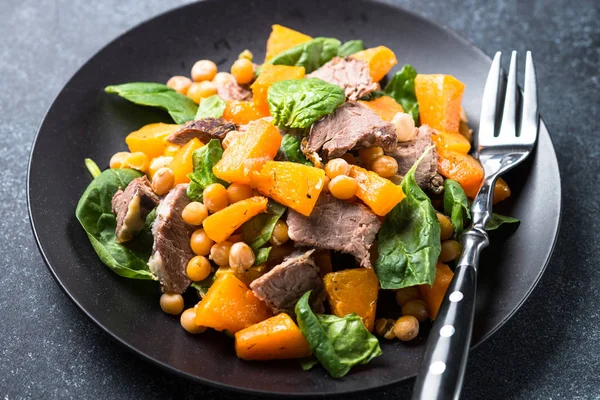 Warmer Salat mit Kürbis, gebackenem Rindfleisch, Spinat und Kichererbsen. — Stockfoto