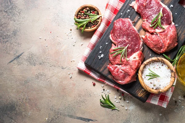 Bife cru com ervas na mesa de pedra. Vista superior . — Fotografia de Stock