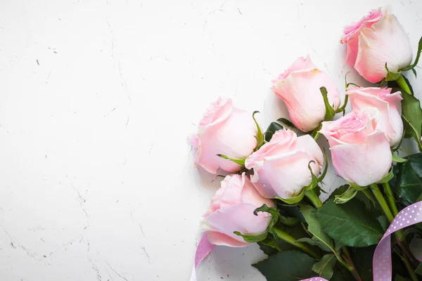 Roze roos aan witte stenen tafel. — Stockfoto