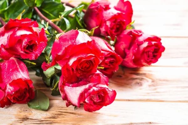 Červené růže květ na dřevěný stůl. — Stock fotografie