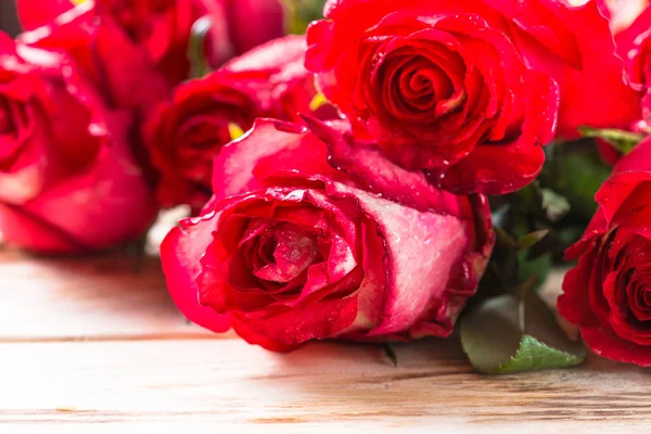 Červené růže květ na dřevěný stůl. — Stock fotografie