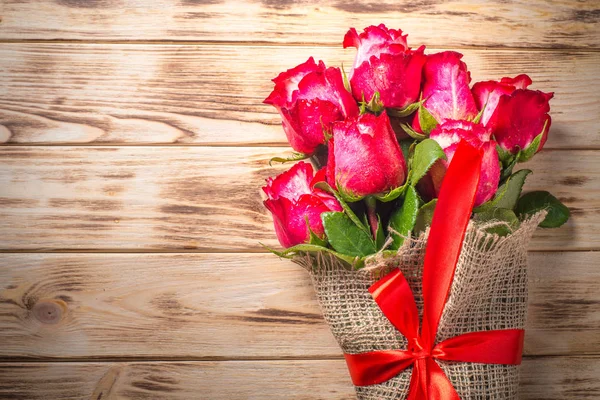 木桌上的红玫瑰花. — 图库照片