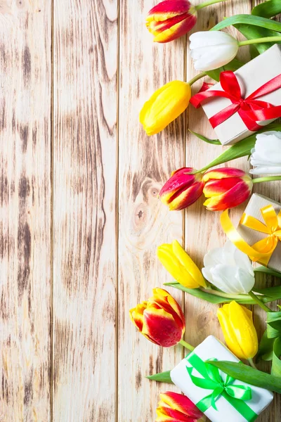 Tulipanes flor y caja presente en mesa de madera . —  Fotos de Stock