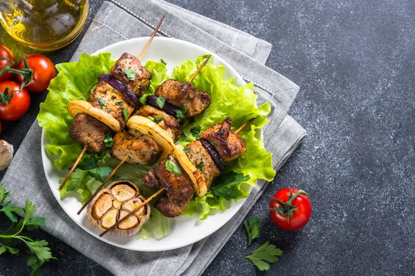 Shish kebab alla griglia o shashlik sul tavolo di pietra nera . — Foto Stock