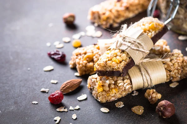 Granola barlar karanlık taş masada. 