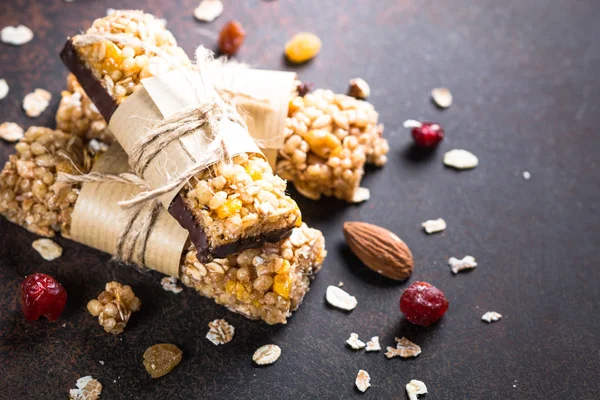Granola barlar karanlık taş masada. 