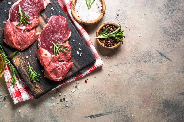 Raw beef steak with herbs on stone table. Top view. — Stock Photo, Image