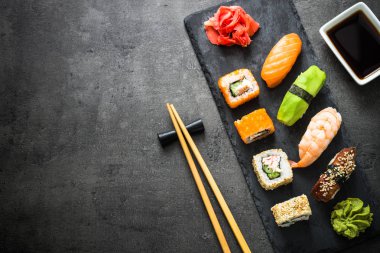 Suşi ve sushi set siyah taş tablo üstten görünüm üzerinde rulo