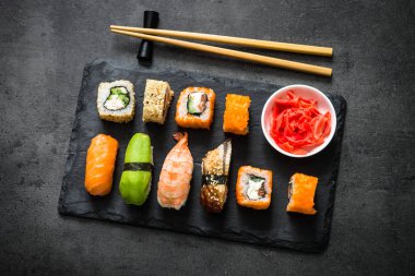 Suşi ve sushi set siyah taş tablo üstten görünüm üzerinde rulo