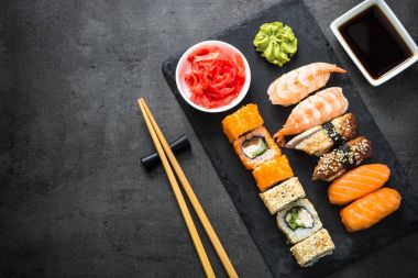 Suşi ve sushi set siyah taş tablo üstten görünüm üzerinde rulo