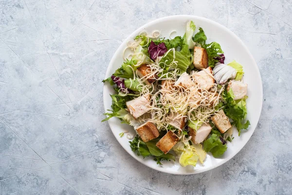 Caesar salad in white plate top view. — Stock Photo, Image