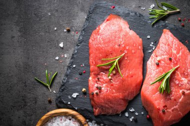 Biberiye ve baharat siyah arka plan üzerine sığır eti biftek