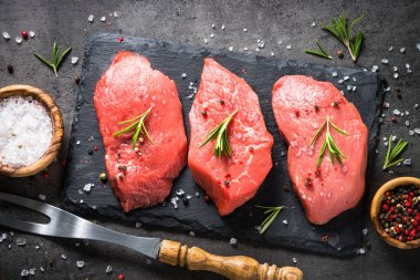 Biberiye ve baharat siyah arka plan üzerine sığır eti biftek