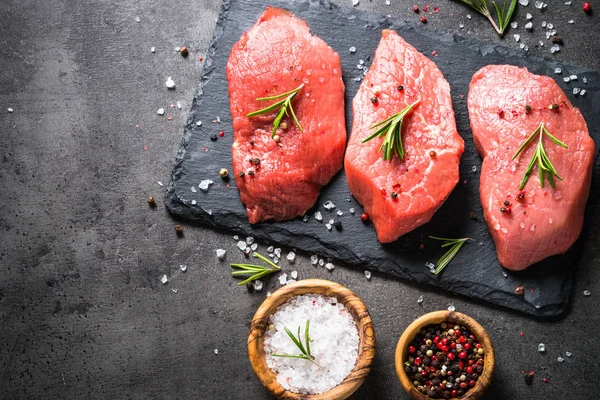 Steak sapi dengan rosemary dan rempah-rempah di latar belakang hitam — Stok Foto