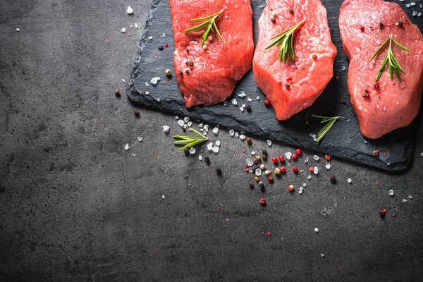 Biefstuk met rozemarijn en specerijen op zwarte achtergrond — Stockfoto