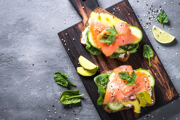 Открытый сэндвич со шпинатом из лосося и авокадо . — стоковое фото