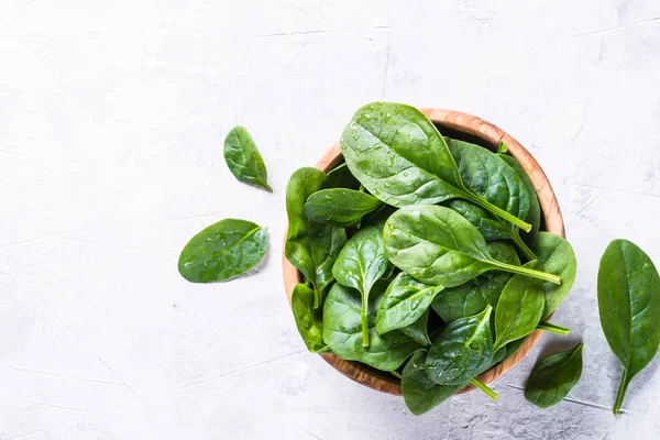 Baby spinach on gray stone table top view. — Stock Photo, Image
