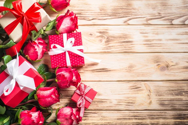 Ferienhintergrund. Blume und Geschenk auf Holztisch. — Stockfoto