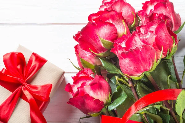 Rood roze bloem en huidige vak op houten tafel. — Stockfoto