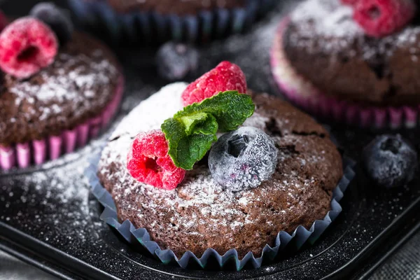 Schokolade Orange Muffins oder Cupcakes mit Beeren. — Stockfoto