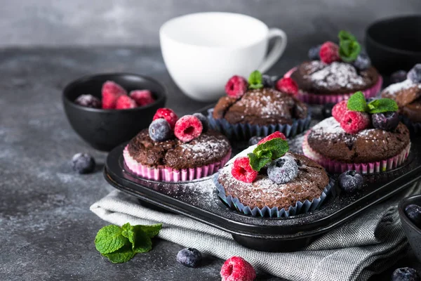 Chocolate orange muffins or cupcakes with berries. — Stock Photo, Image