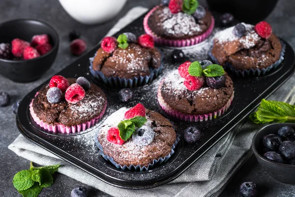 Choklad orange muffins eller cupcakes med bär. — Stockfoto