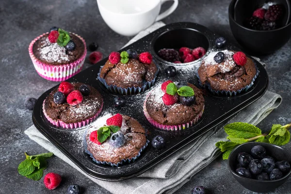 Choklad orange muffins eller cupcakes med bär. — Stockfoto