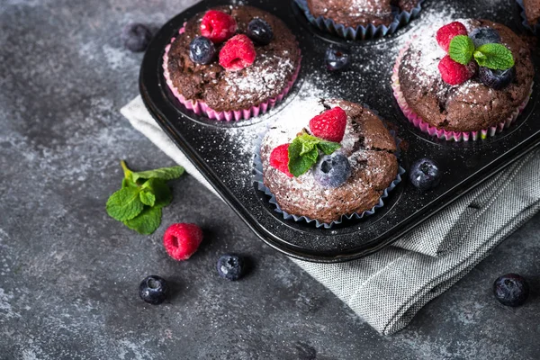 Chocolate orange muffins or cupcakes with berries. — Stock Photo, Image