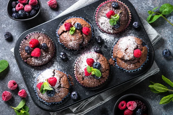 Chocolate orange muffins or cupcakes with berries. — Stock Photo, Image