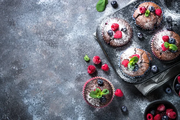 Schokolade Orange Muffins oder Cupcakes mit Beeren. — Stockfoto