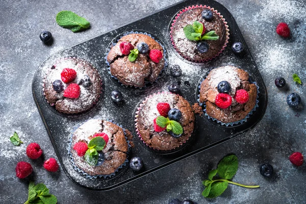 Chocolate orange muffins or cupcakes with berries. — Stock Photo, Image