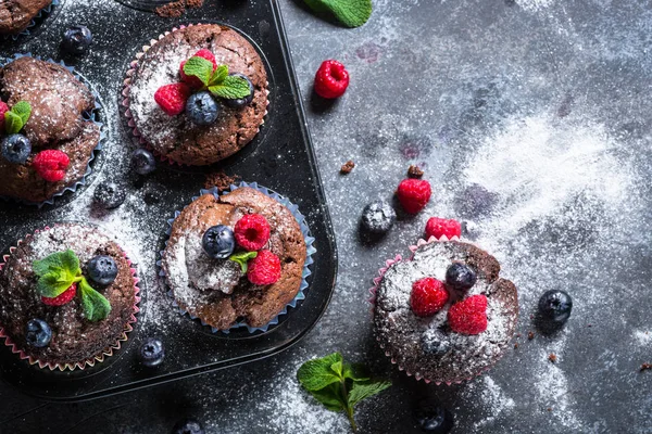 Chocolate orange muffins or cupcakes with berries. — Stock Photo, Image