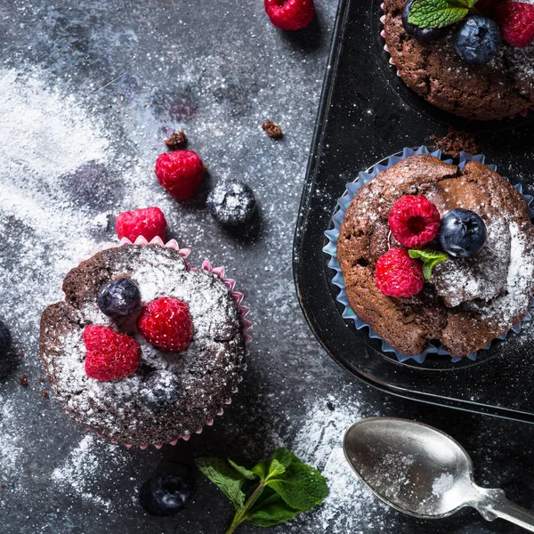 Czekoladowe muffiny pomarańczowe lub babeczki z jagodami. — Zdjęcie stockowe