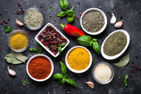 Set van verschillende kruiden en specerijen op zwarte stenen tafel. — Stockfoto