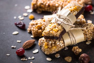 Granola barlar karanlık taş masada. 