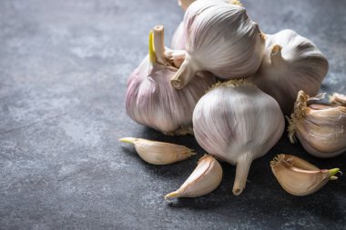 Karanlık bir taş zemin üzerine diş sarımsak. 