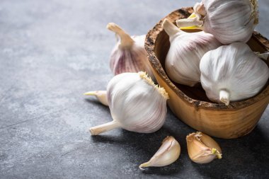 Karanlık bir taş zemin üzerine diş sarımsak. 