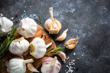 Baharatlar ve otlar karanlık bir taş zemin üzerine diş sarımsak. 