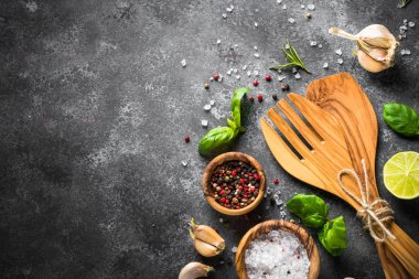 Otlar, baharatlar ve mutfak eşyaları siyah bir taş tablo.