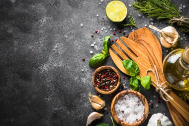 Zeytinyağı, otlar ve baharatlar karanlık bir taş tablo. 