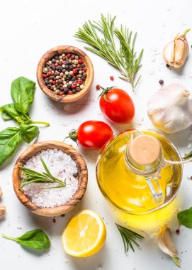 Baharatlar, otlar ve zeytinyağı beyaz taş tablo üzerinde. 